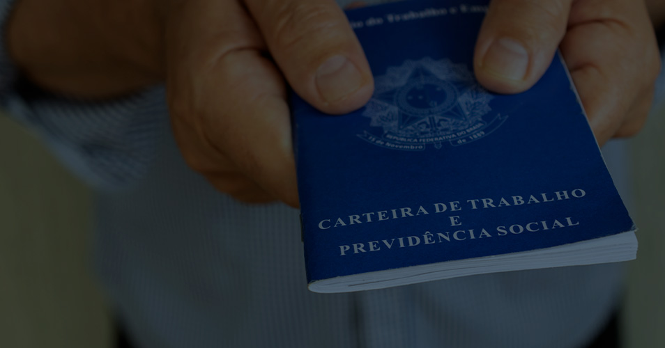Foto que ilustra direito trabalhista e conta com uma mão segurando uma carteira de trabalho.